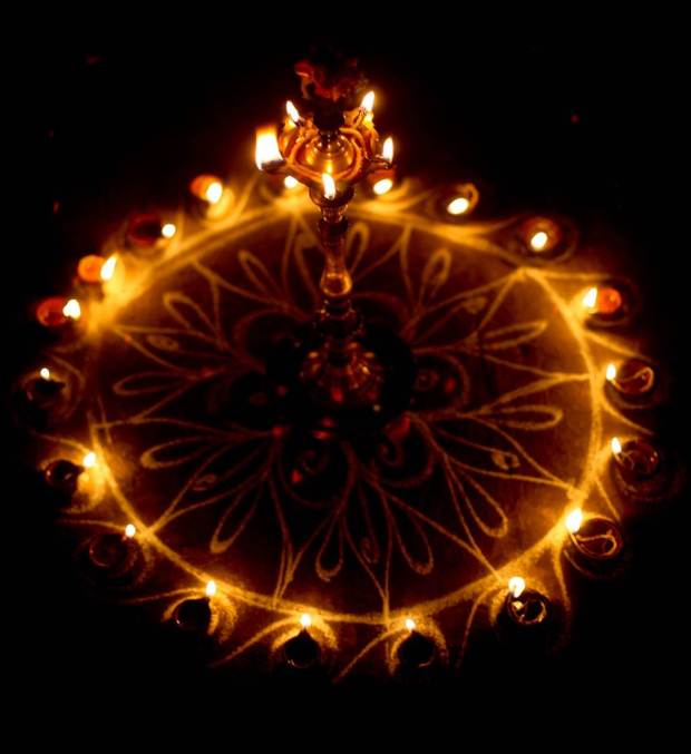 This image shows a kolam decked out with tiny lamps. Women all over Tamil Nadu create kolams outside their homes every morning, they are thought to bestow prosperity to homes. Drawn on the ground with white rice powder or chalk powder the drawings usually get walked on, rained out, or blown away by the wind but during Karthikai Deepam they were preserved and then embellished.