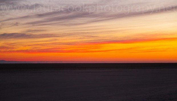 The salt flats provide a blank canvas as the sun begins to warm up the sky.
