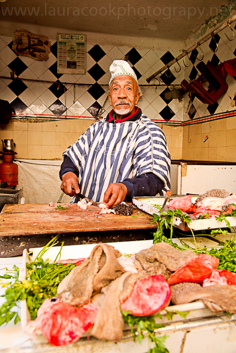A serious butcher cuts meat ready for the constant stream of customers in the souk.