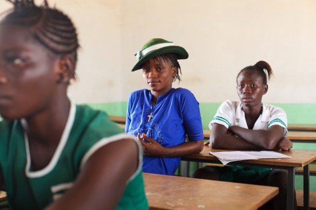 Rabiatu sits in class learning about verbs (Makeni, Sierra Leone). Nearly just as many girls as boys start secondary school in Sierra Leone but many drop out before they reach Rabiatu's age. Staying in school gives young girls many more options though and as Rabiatu said, "with education I can be whoever I want to be."