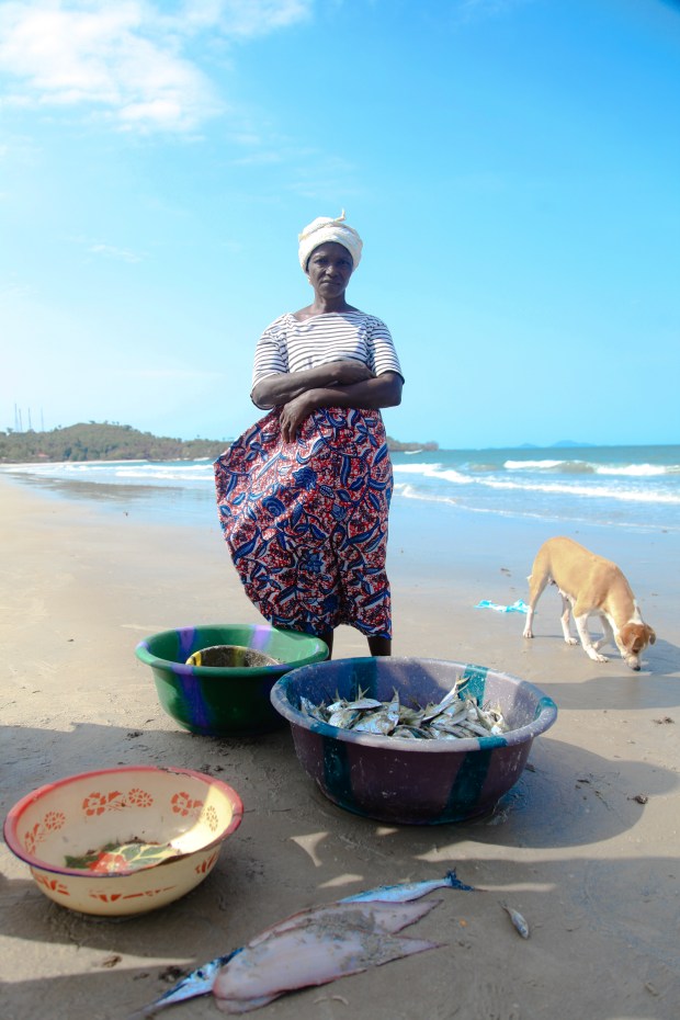 Finally each woman has her precious cargo and is ready to carry it away from the group for smoking and sale. She will return tomorrow to rely once again on the men at sea and her fellow women when the catch comes in.